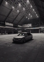 A sleek, modern workspace with a luxury car being serviced under soft industrial lighting