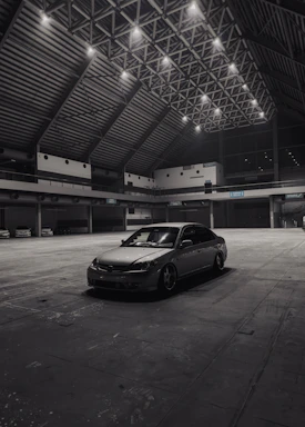 A sleek, modern workspace with a luxury car being serviced under soft industrial lighting