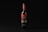 A wine bottle with a black and red label stands upright against a dark background. The label features intricate typography and design elements, with the word 'Вино' prominently displayed.