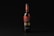 A wine bottle with a black and red label stands upright against a dark background. The label features intricate typography and design elements, with the word 'Вино' prominently displayed.