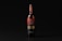 A wine bottle with a black and red label stands upright against a dark background. The label features intricate typography and design elements, with the word 'Вино' prominently displayed.