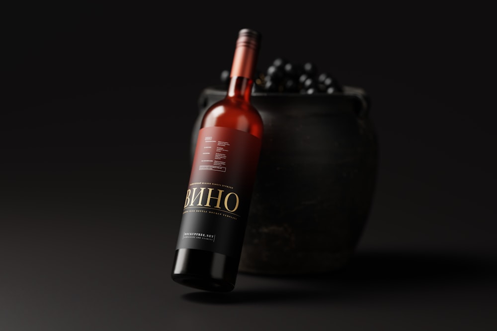 a bottle of wine sitting next to a black pot