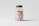A clear plastic bottle with a gray lid is filled with light pink tablets. The bottle has the text 'MOCP' printed in black on the front along with additional information and a website link near the bottom.
