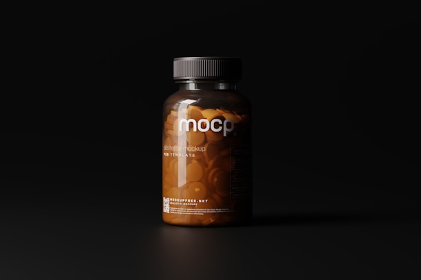 A dark-toned image showcasing a clear plastic bottle filled with orange pills under soft lighting. The bottle has a black cap and features minimalist labeling with the letters 'mocp' prominently displayed.