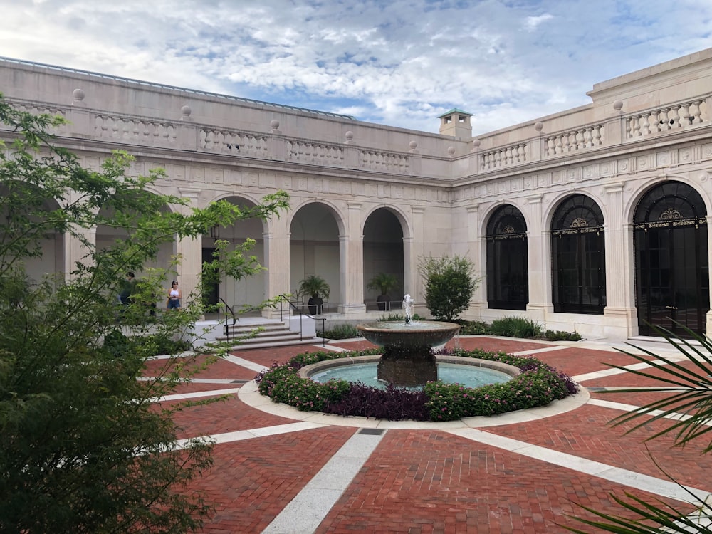 a courtyard with a fountain in the middle of it