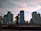 Two friends jogging together at dawn, sharing a laugh, with city skyline in the background.