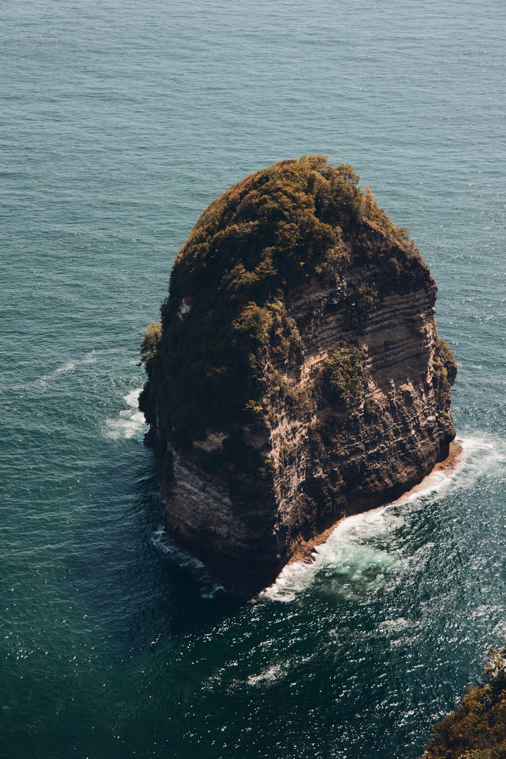 a large rock in the middle of the ocean