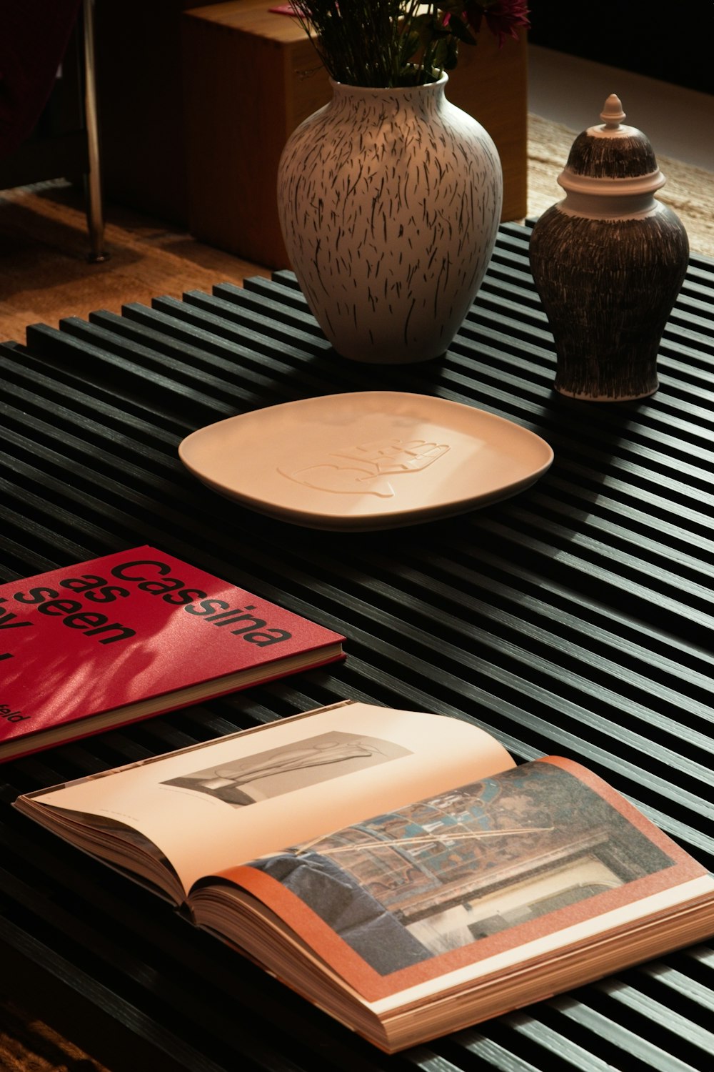 a table topped with a book and a vase filled with flowers