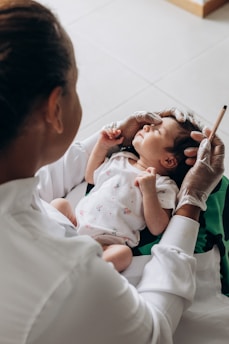 a woman holding a baby in her lap in Rini Hospital Dholpur 