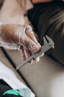 Hands carefully measuring the length of a cotton kurti on a wooden table.