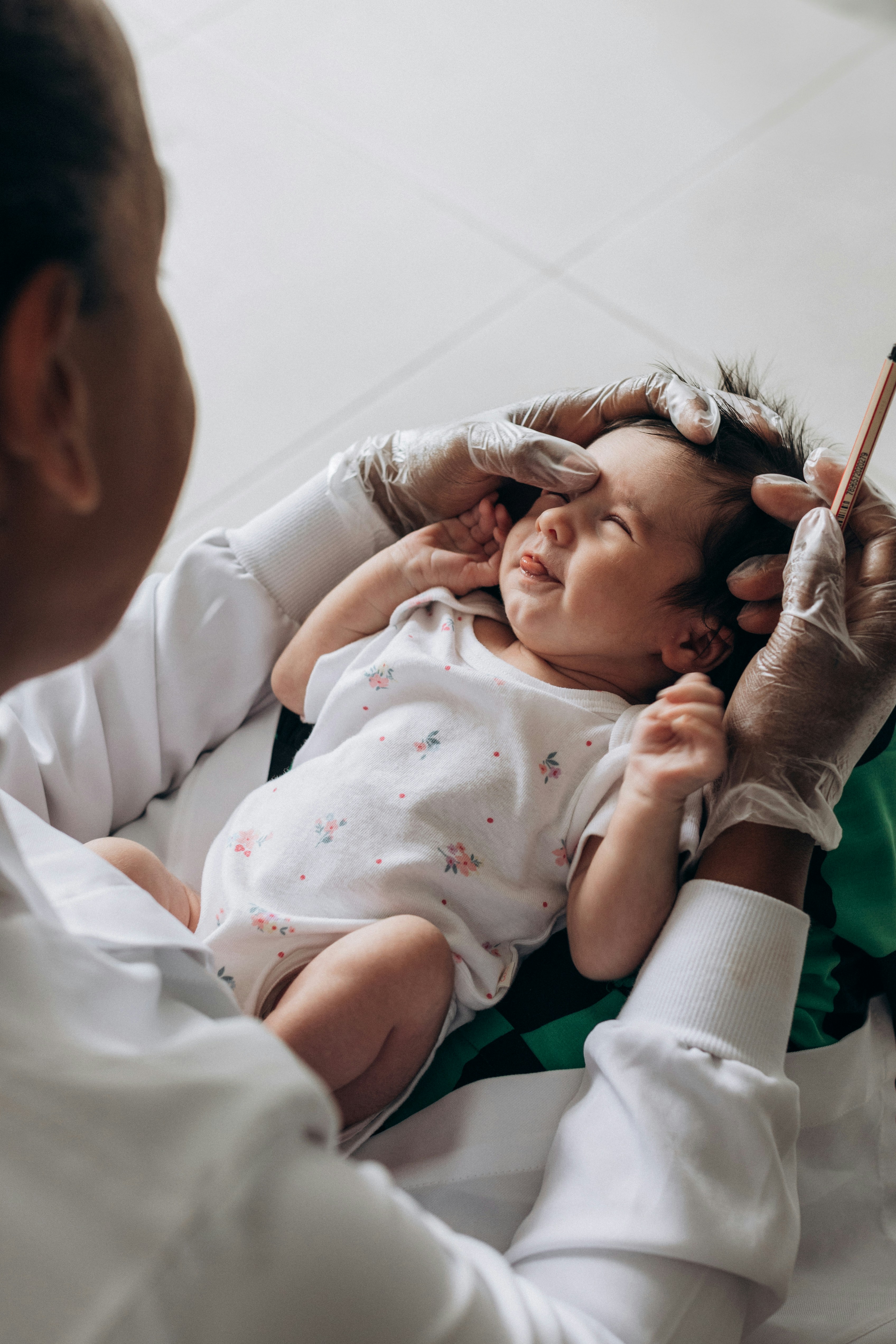 a baby being examined by a doctor in a room