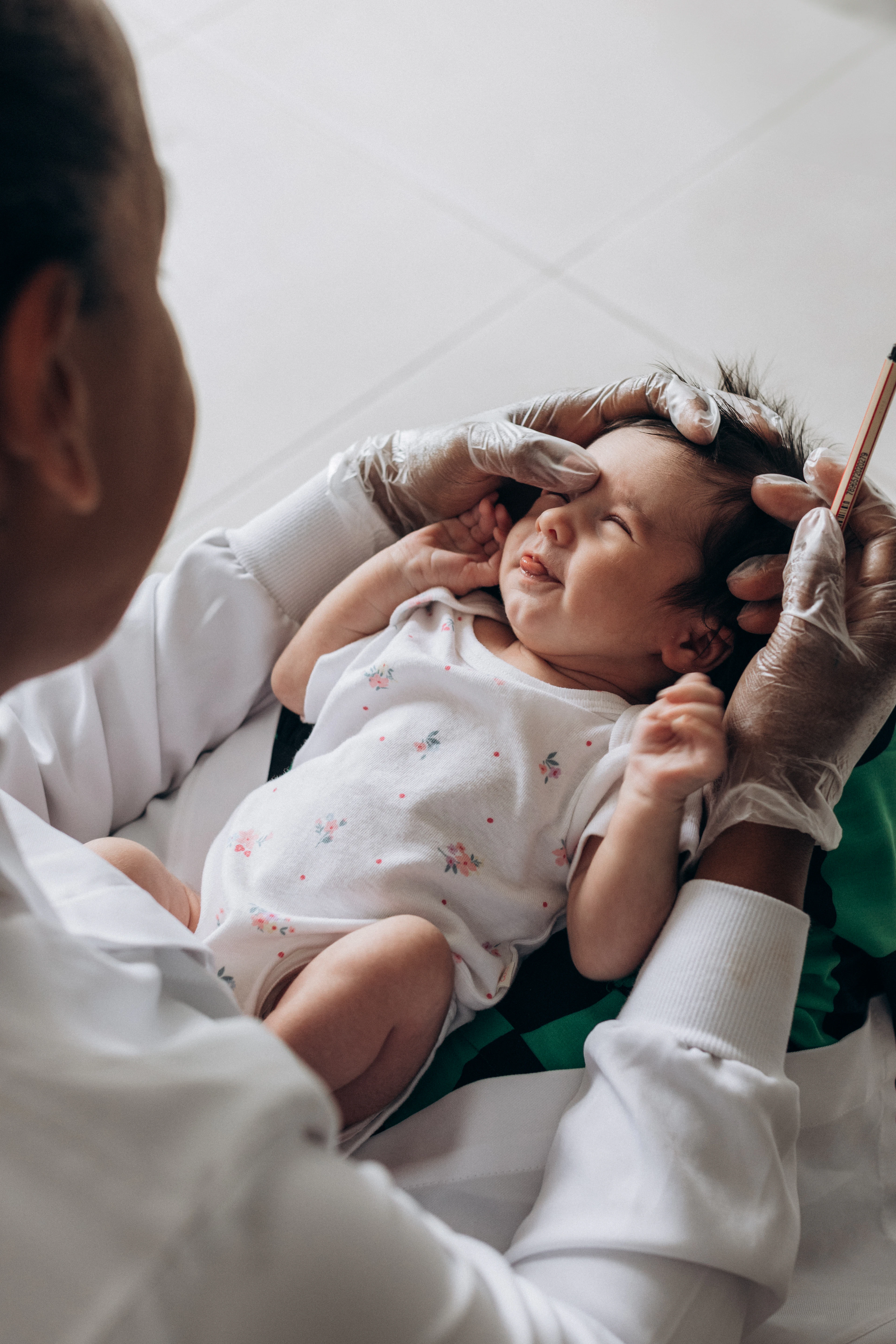 Pediatra examinando com cuidado um bebê recém-nascido