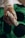 A gloved hand holds a sterile medical device, possibly for blood testing or sample collection, with a green and black background.