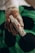 A gloved hand holds a sterile medical device, possibly for blood testing or sample collection, with a green and black background.