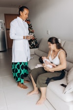 a woman holding a baby while sitting on a couch
