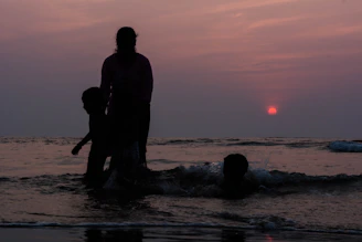 Sunset over Ipanema beach with silhouettes of people enjoying the shore