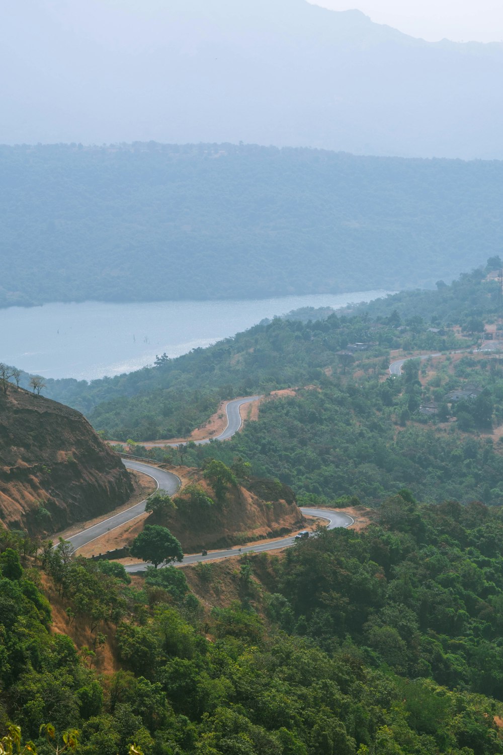 a scenic view of a winding road in the mountains