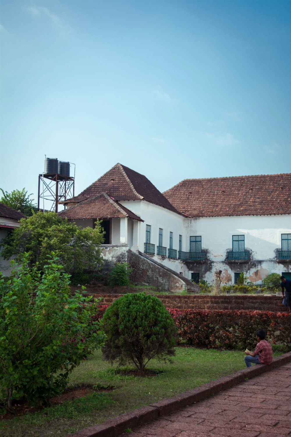 a person sitting on the ground in front of a house