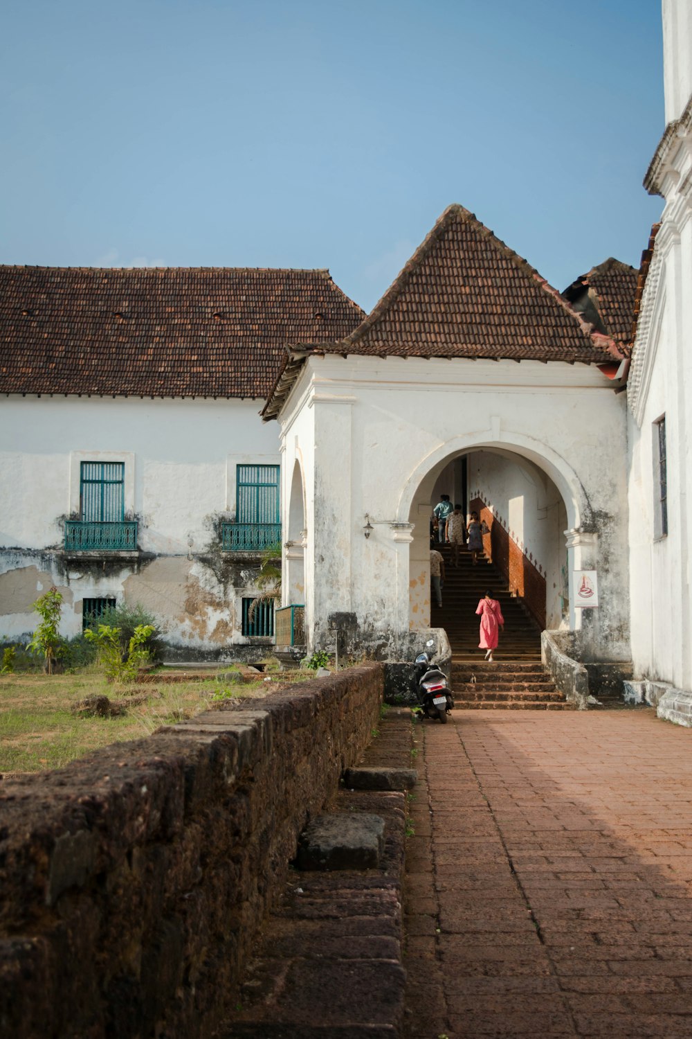 a white building with a brick walkway leading to it