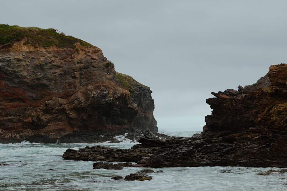 a couple of large rocks sitting on top of a beach