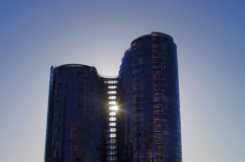 Le soleil brille derrière deux grands immeubles