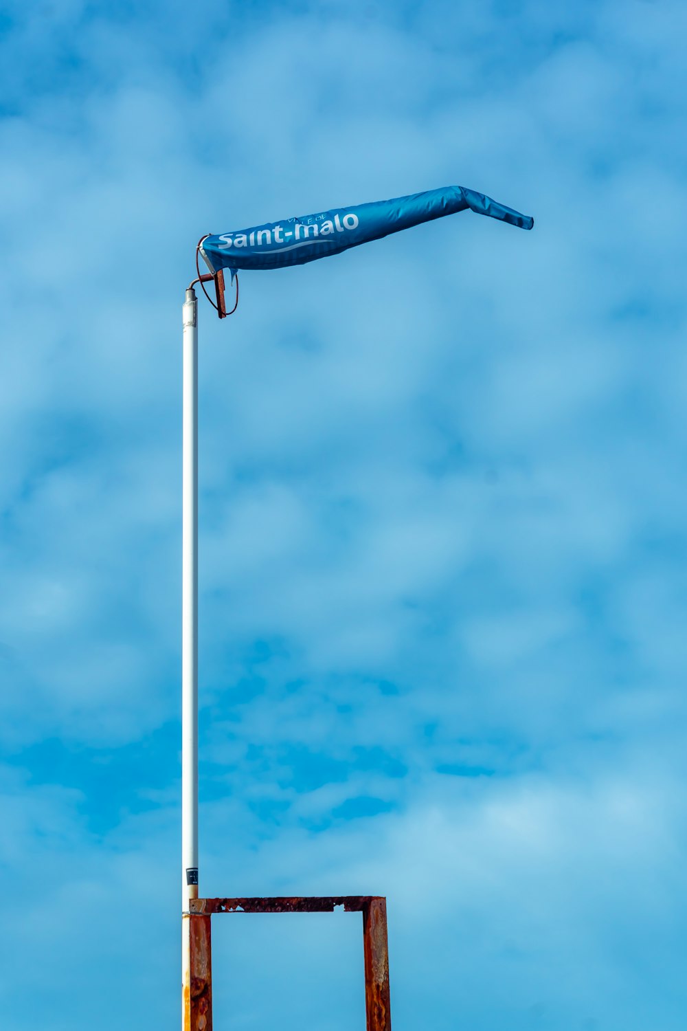a blue and white flag on top of a pole