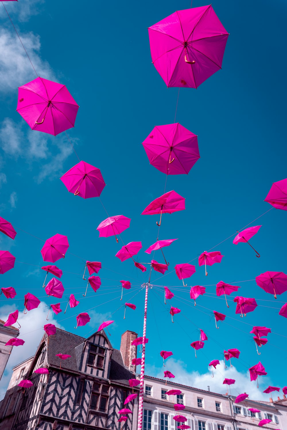 a bunch of pink umbrellas flying in the air