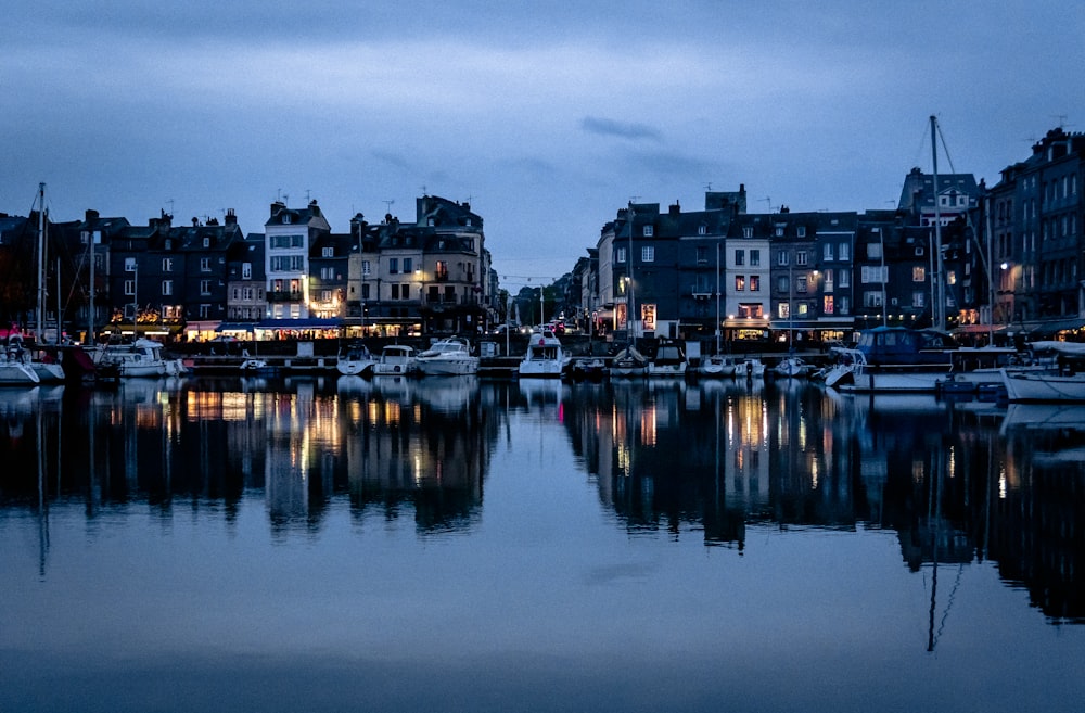 a harbor filled with lots of boats next to tall buildings