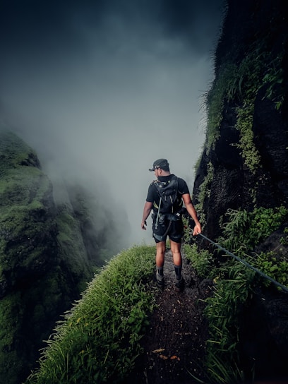 Alex standing on a misty mountain trail in Romania, looking thoughtfully into the distance.