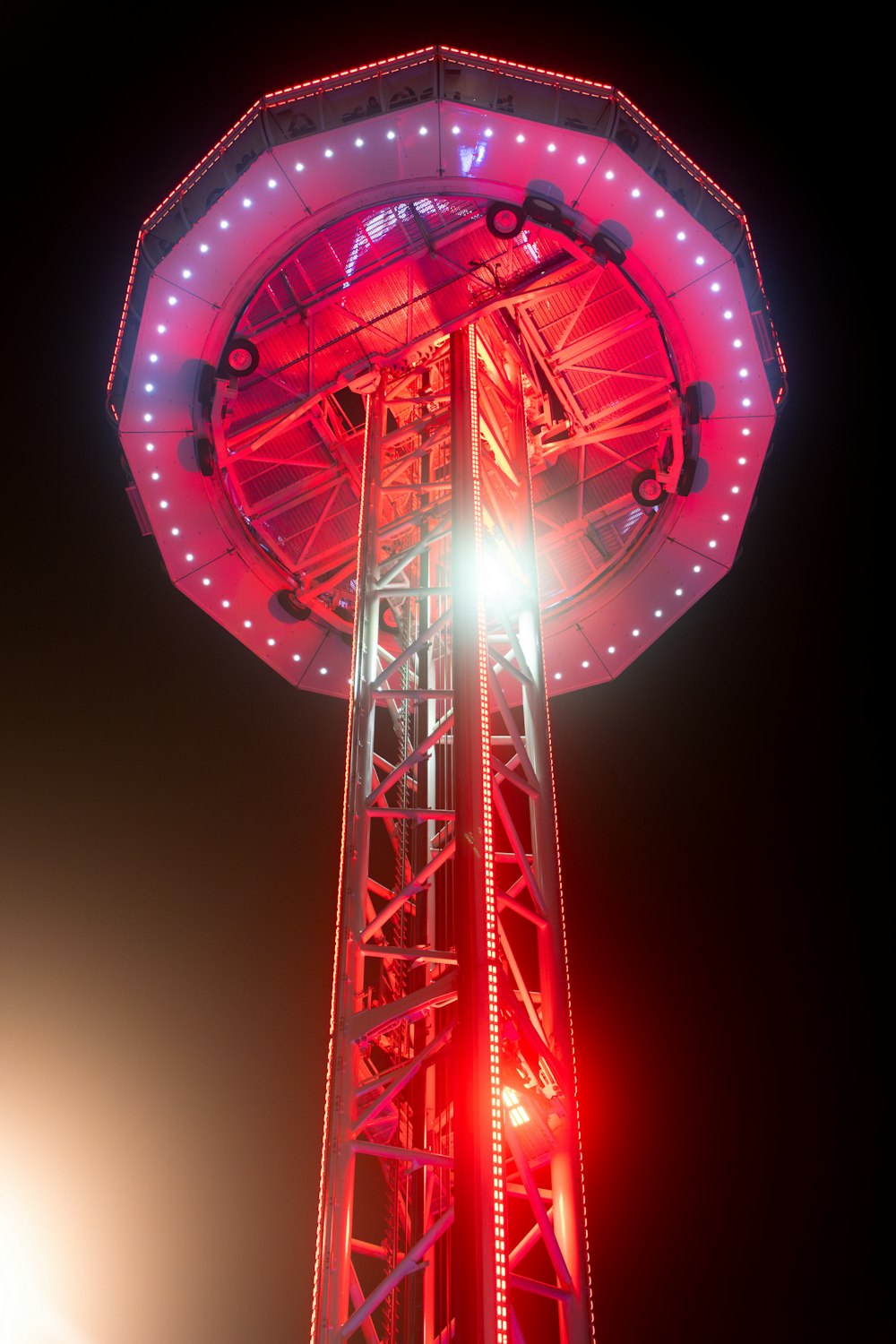 a ferris wheel lit up at night with bright lights