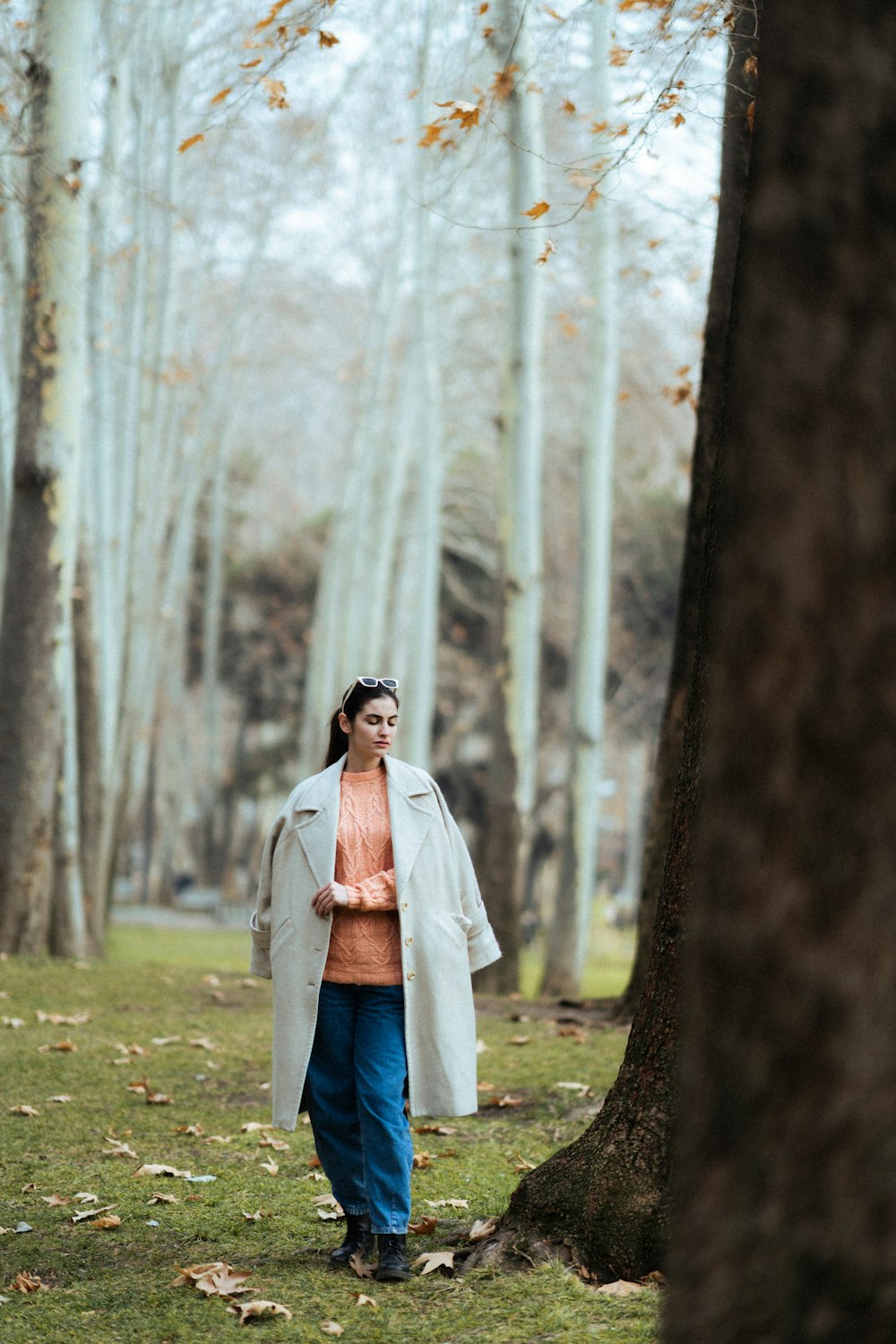 a woman standing in the middle of a forest