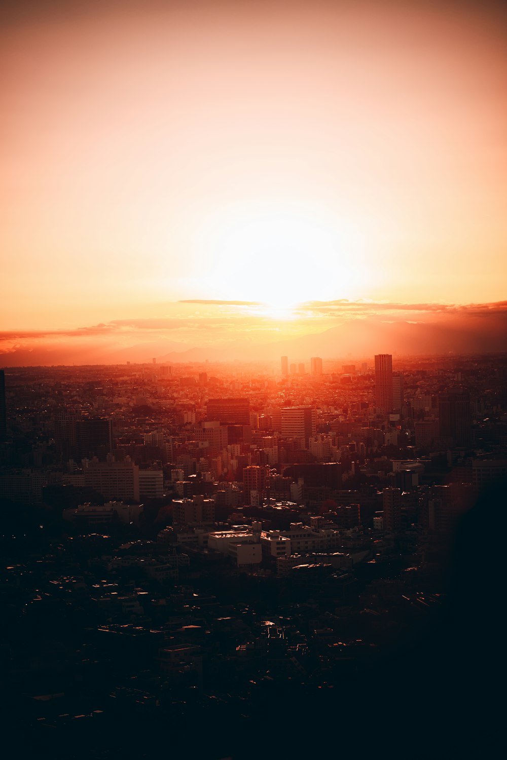 the sun is setting over a city with tall buildings