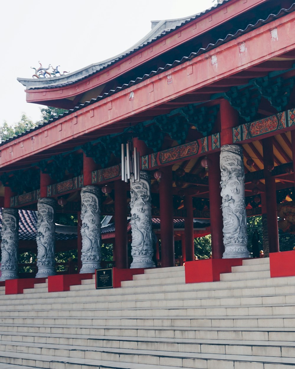 a red and white building with columns and a clock