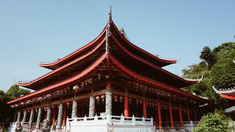 a tall building with a red roof surrounded by trees