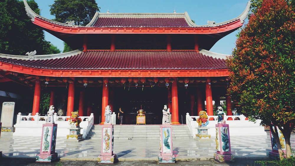 a red and white building with statues in front of it