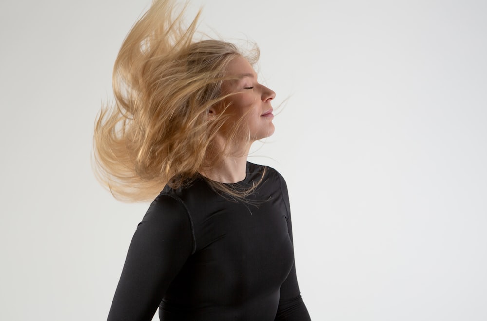 a woman with her hair blowing in the wind