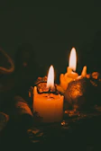 Candles lit in an urban apartment setting, casting warm light on contemporary decor.
