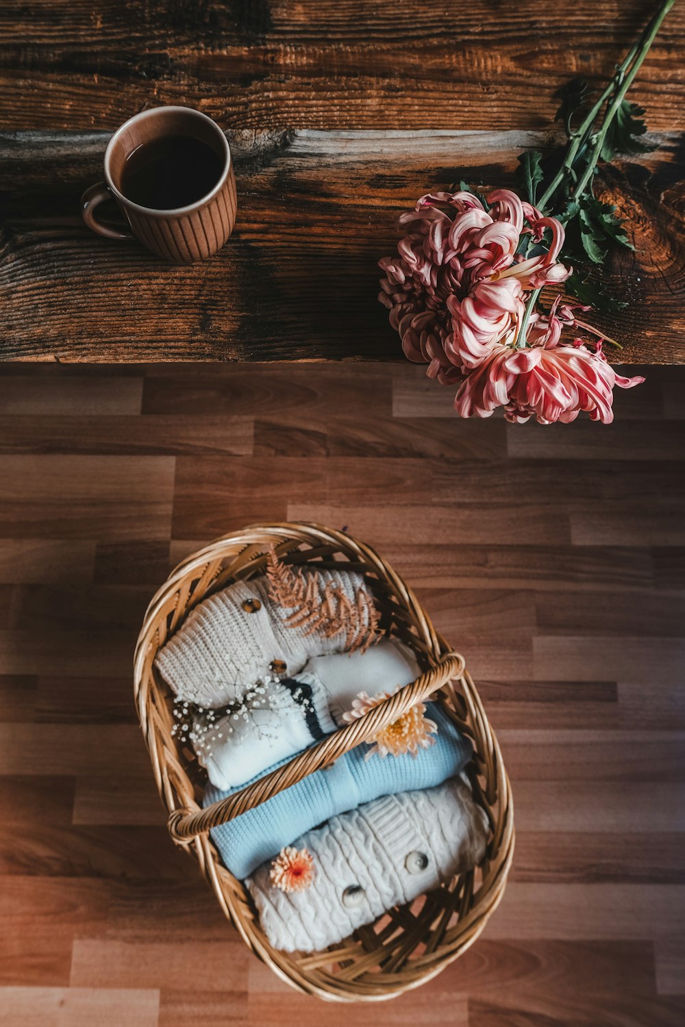 a basket filled with blankets next to a cup of coffee
