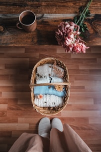 Elegant cotton slippers with a plush lining, placed beside a steaming cup of tea on a small table.