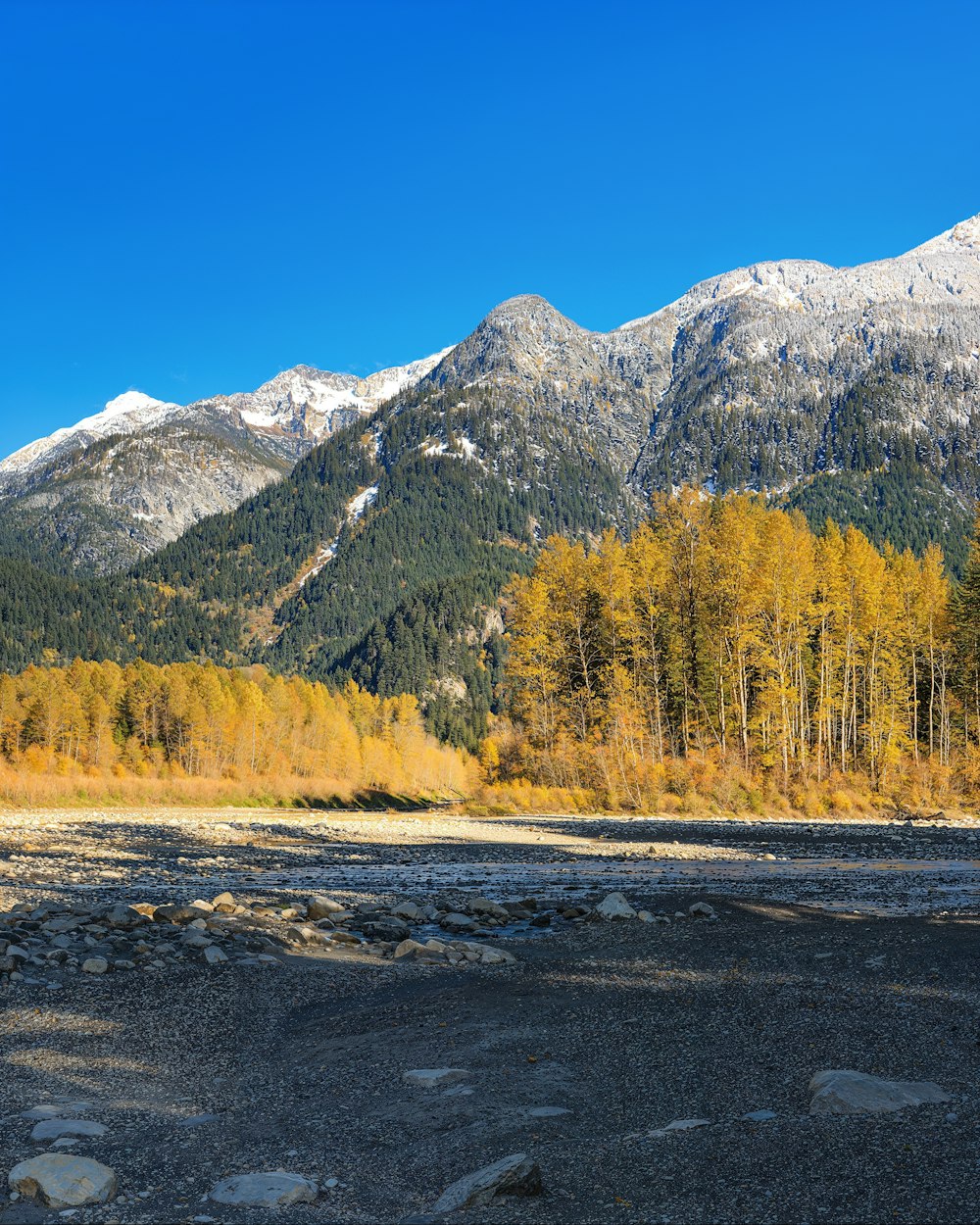 a scenic view of a mountain range with a river in the foreground