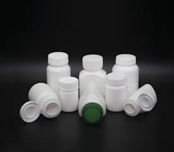 Plastic rigid containers such as bottles and cream pots, displayed with their tops, highlighting injection molding precision.