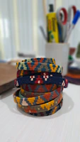 A stack of colorful gemstone bracelets catching the light on a rustic wooden table.