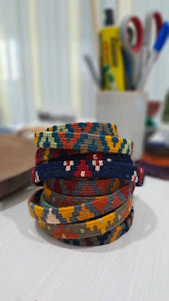 Close-up of colorful handmade bracelets woven on an Egyptian loom, showcasing intricate patterns and vibrant threads.