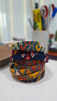 Close-up of colorful handmade crochet bracelets arranged on a rustic wooden table.