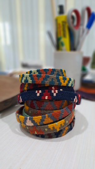 Close-up of colorful handmade macramé bracelets with crystal beads on a rustic wooden table.