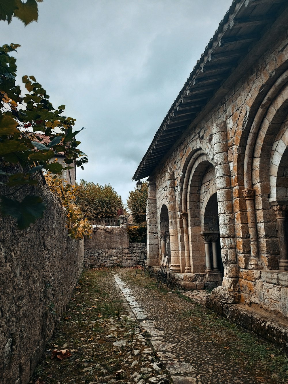a stone building with arches and a stone walkway