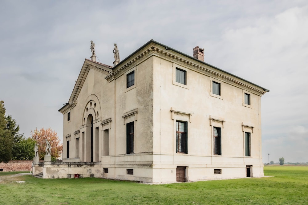 Ein großes weißes Gebäude, das auf einer üppig grünen Wiese sitzt