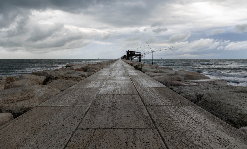 a long concrete pier stretching out into the ocean