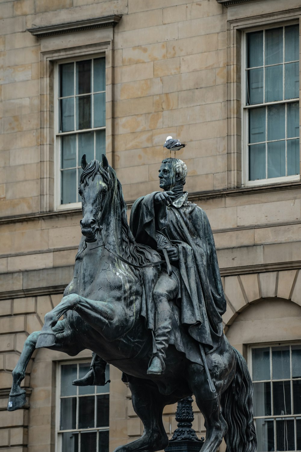 a statue of a man on a horse in front of a building