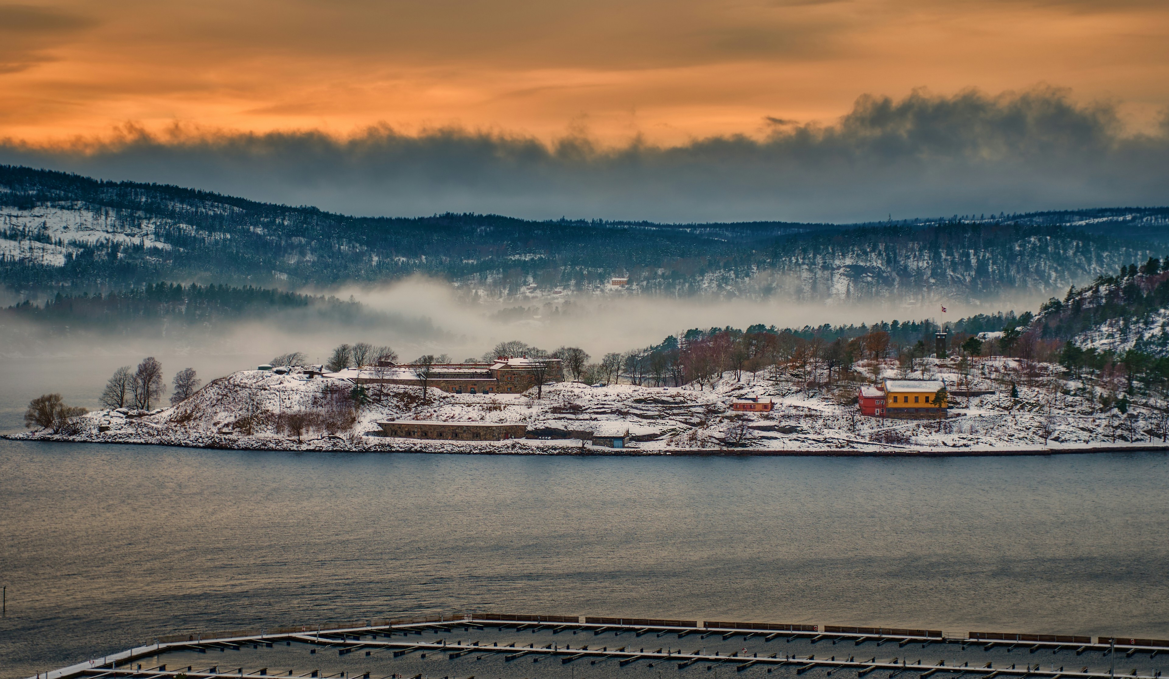 a large body of water surrounded by snow covered mountains